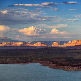 The setting sun peaks through the clouds at Lake Powell.