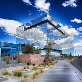 Mirror-like windows on the Marina Heights building at Tempe Town Lake reflect the clouds making the building look transparent and surreal.